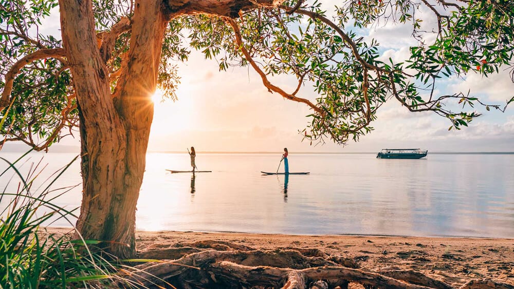 Caravan Parks in Noosa & Surrounds 7 Two girls paddle boarding at Habitat Noosa, one of the caravan parks in Noosa