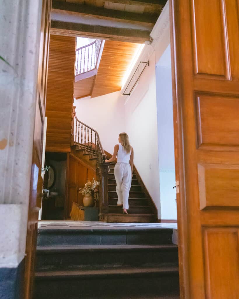 El Patio 77: Sustainable Bed and Breakfast Mexico City 2 Sally walking a historic spiral wooden staircase in a light filled room at El Patio 77 in Mexico City