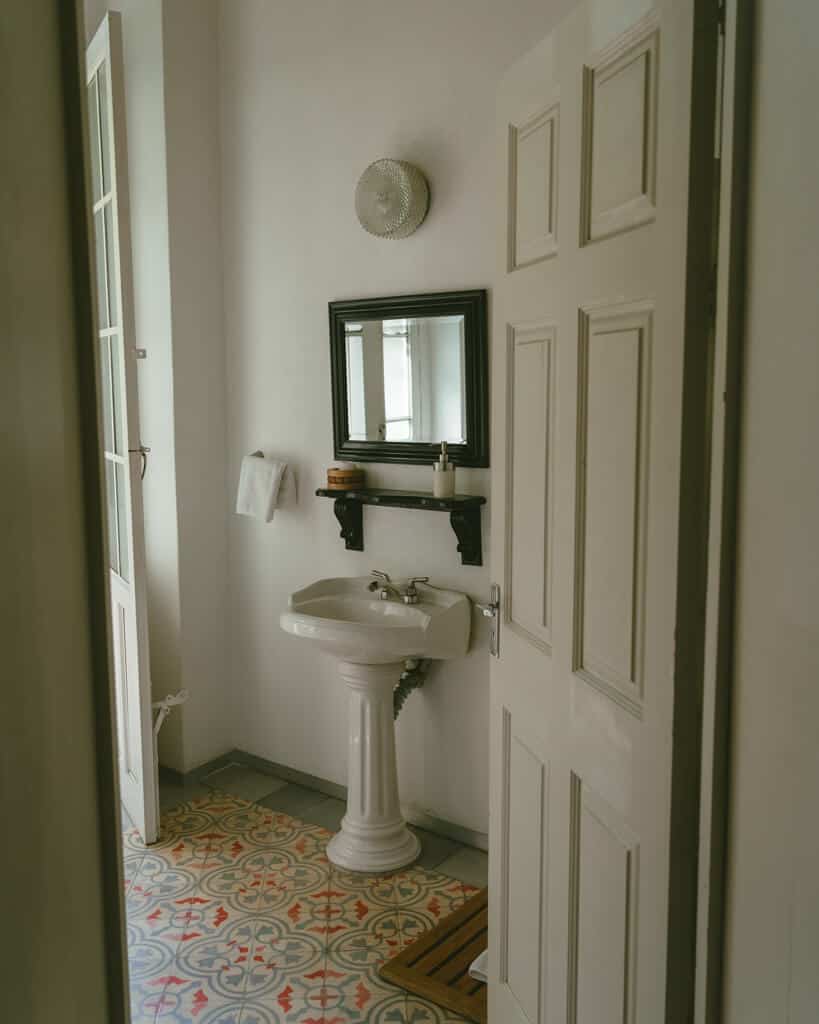 El Patio 77: Sustainable Bed and Breakfast Mexico City 14 A historic style hotel bathroom with blue and pink patterned wall tiles and a vintage single basin