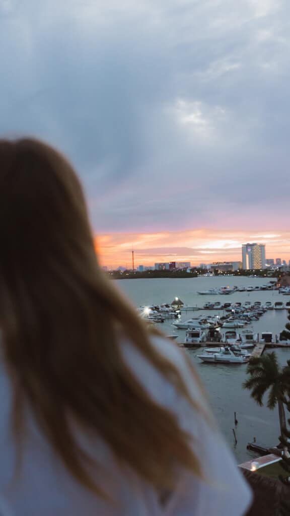 Casa Tortugas Boutique Hotel - Sustainable Accommodation in Cancun 31 Sally overlooking a sunset against the lagoon and city skyline in Cancun