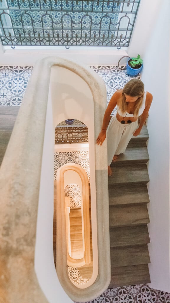 Casa Tortugas Boutique Hotel - Sustainable Accommodation in Cancun 26 Sally walking down a flight of stairs with a view down the centre of the staircase