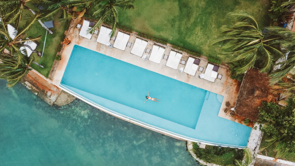 Casa Tortugas Boutique Hotel - Sustainable Accommodation in Cancun 18 A drone shot of Sally floating in an infinity pool set right next to a lagoon