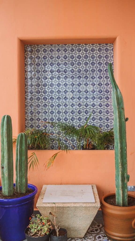 Casa Tortugas Boutique Hotel - Sustainable Accommodation in Cancun 5 An orange wall with a niche with blue patterned tiles at Casa Tortugas Boutique Hotel