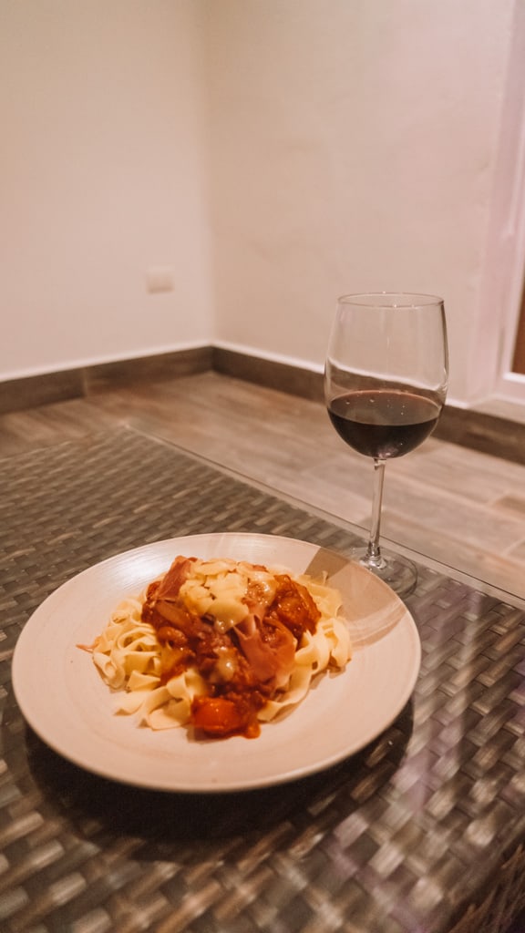 Casa Tortugas Boutique Hotel - Sustainable Accommodation in Cancun 12 A plate of spaghetti bolognese with a glass of red wine