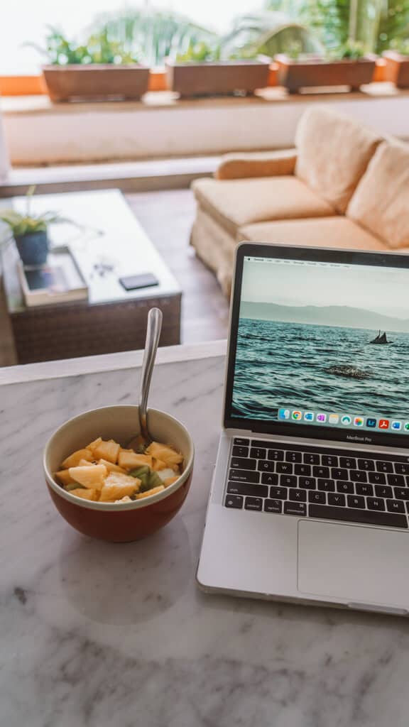 Casa Tortugas Boutique Hotel - Sustainable Accommodation in Cancun 23 A bowl of fruit sitting next to an Apple Mac laptop