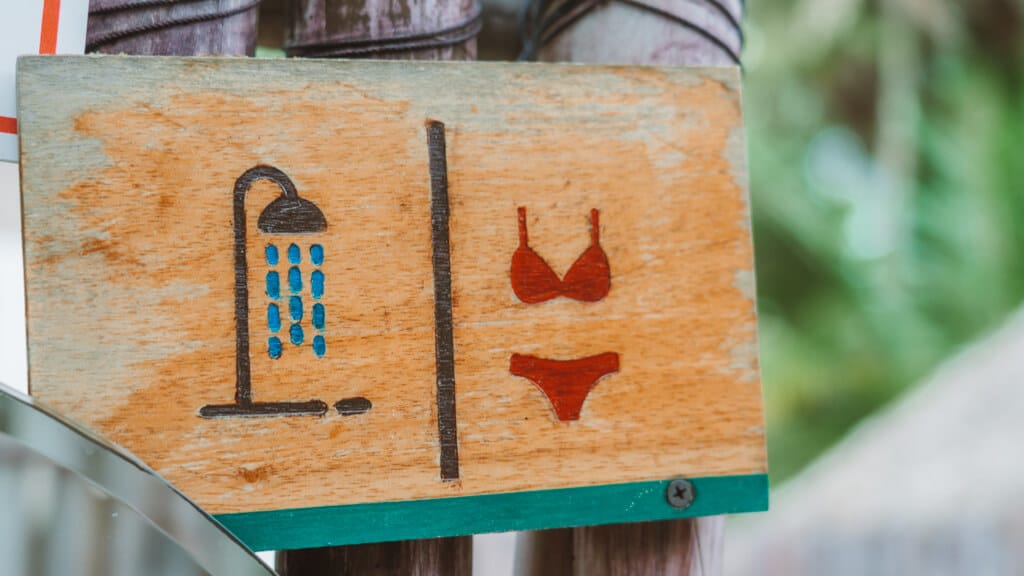 Glamping at Hotel Cielo y Selva in the Sian Ka'an Biosphere Reserve 44 A wooden sign with a shower and bikini symbol