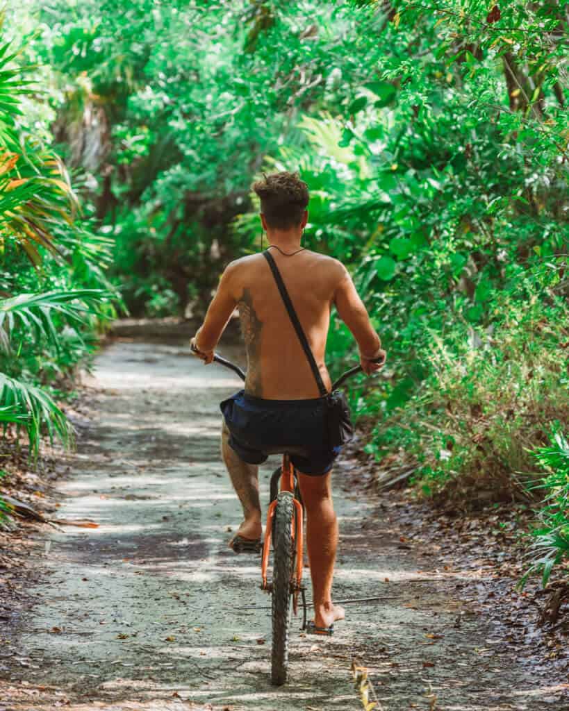 Glamping at Hotel Cielo y Selva in the Sian Ka'an Biosphere Reserve 42 Brayden riding a bicycle on a path lined with lush green jungle