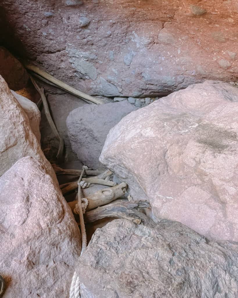 Tabor Canyon, Loreto Hiking Guide 10 A rugged section of a rocky canyon trail featuring a rope and driftwood ladder wedged between massive stone walls, used by hikers for navigating steep terrain.