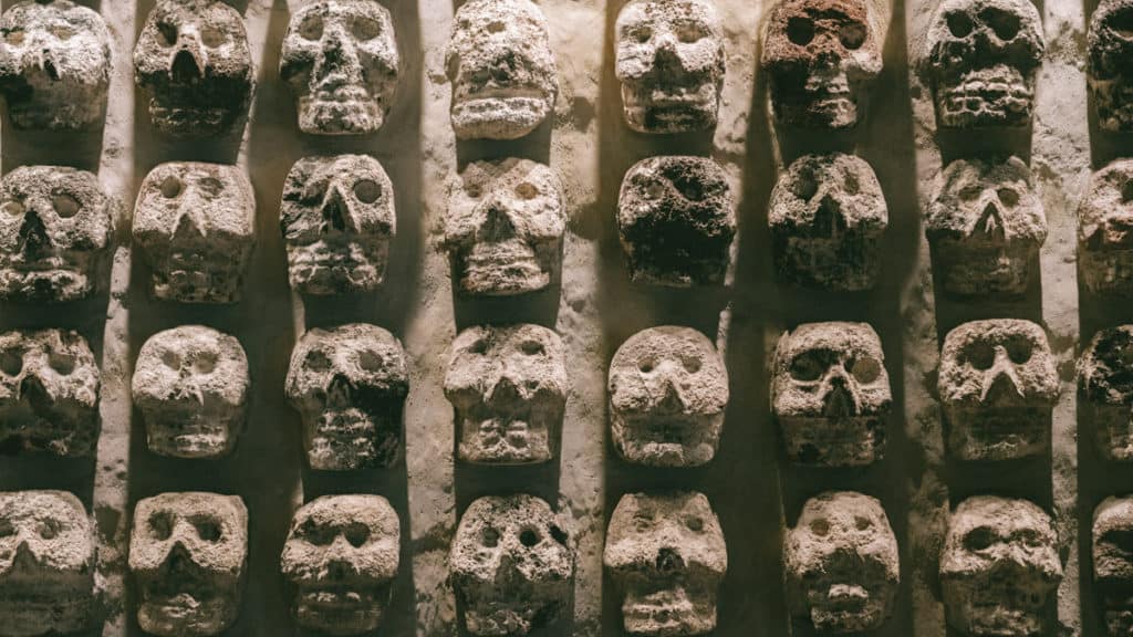 Four rows of ancient stone faces in the Templo Mayor museum in Mexico City 