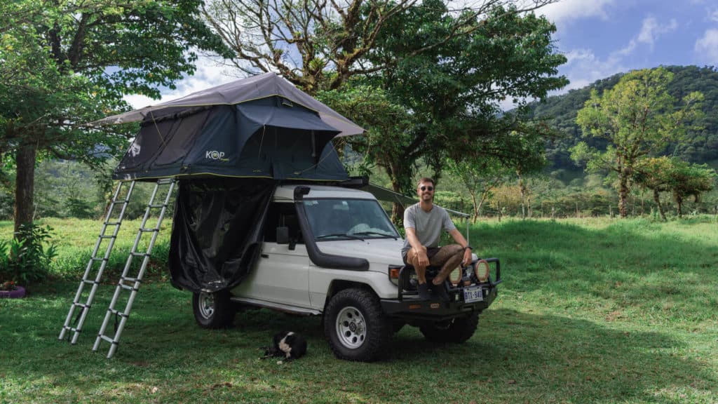 Bajos del Toro Travel Guide: Costa Rica's Waterfall Wonderland 16 Brayden sitting on the front of a Toyota Landcruiser with a rooftop tent set up on top in Bajos del Toro