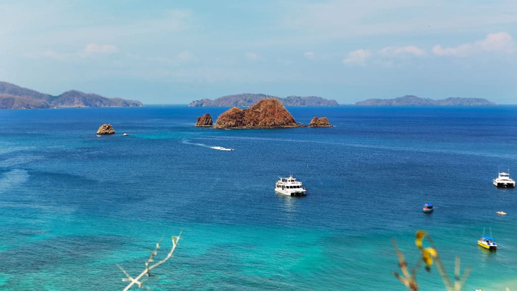 15 Best Things to Do in Montezuma Costa Rica 14 An aerial shot of Tortuga Island near Montezuma Costa Rica on a bright sunny day, with blue water, boats dotted in the ocean and the island in the distance