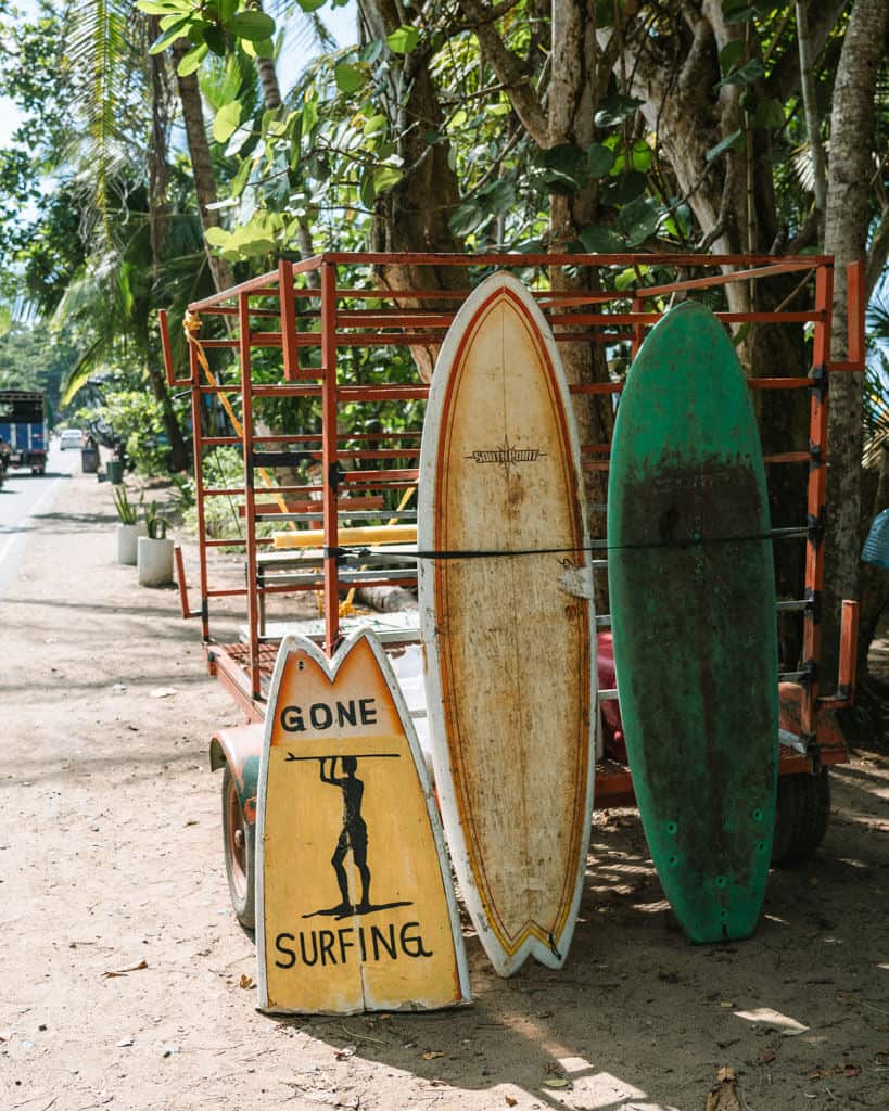 15 Best Things to Do in Montezuma Costa Rica 23 Two surfboards leaning up against a trailer, with a half surfboard with the words 'gone surfing' and a silhouette of a man holding a surfboard above his head
