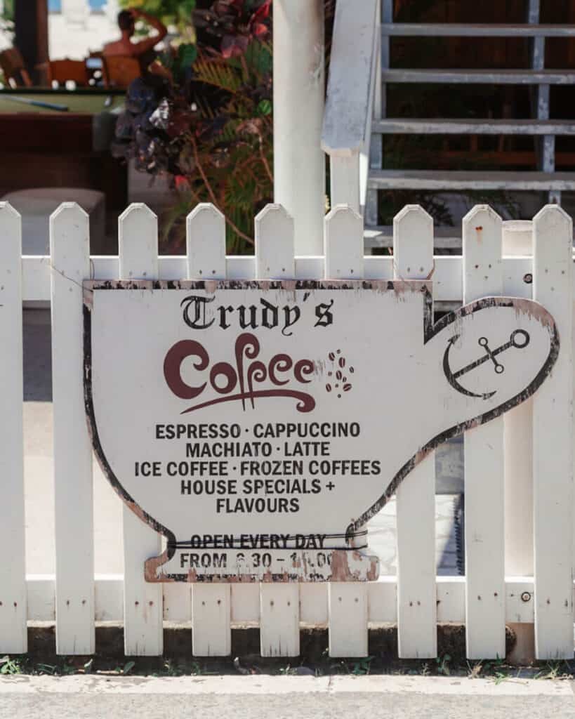 Our Top 10 Restaurants in Utila, Honduras 15 The charming entrance sign of Trudy's Coffee in Utila showcasing their variety of espresso and coffee drinks, inviting visitors to enjoy their offerings daily