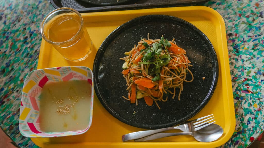 San Pancho Mexico Travel Guide: Tropical Bliss in Nayarit 34 A yellow tray with a bowl of soup, a plate of noodles and a cup with yellow liquid at Burrito Piñata in San Pancho