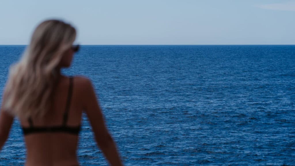 Complete El Salvador Travel Guide 11 A close up of Sally, blurred in the foreground, looking out to the expansive blue Pacific Ocean from the beachfront at Atami Resort in El Tunco.