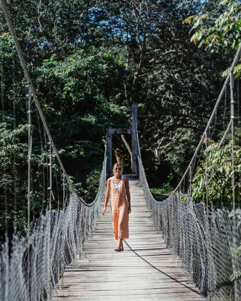 Sally standing on a rickety wooden swing bridge over the Macal River in San Ignacio Belize