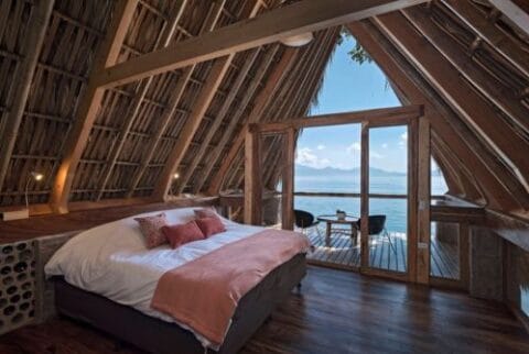 Lake Atitlan Travel Guide: Everything You Need to Know 15 Cozy A-frame cabin bedroom with lakefront balcony views at La Fortuna Atitlán in Santa Cruz La Laguna, Lake Atitlán, Guatemala.