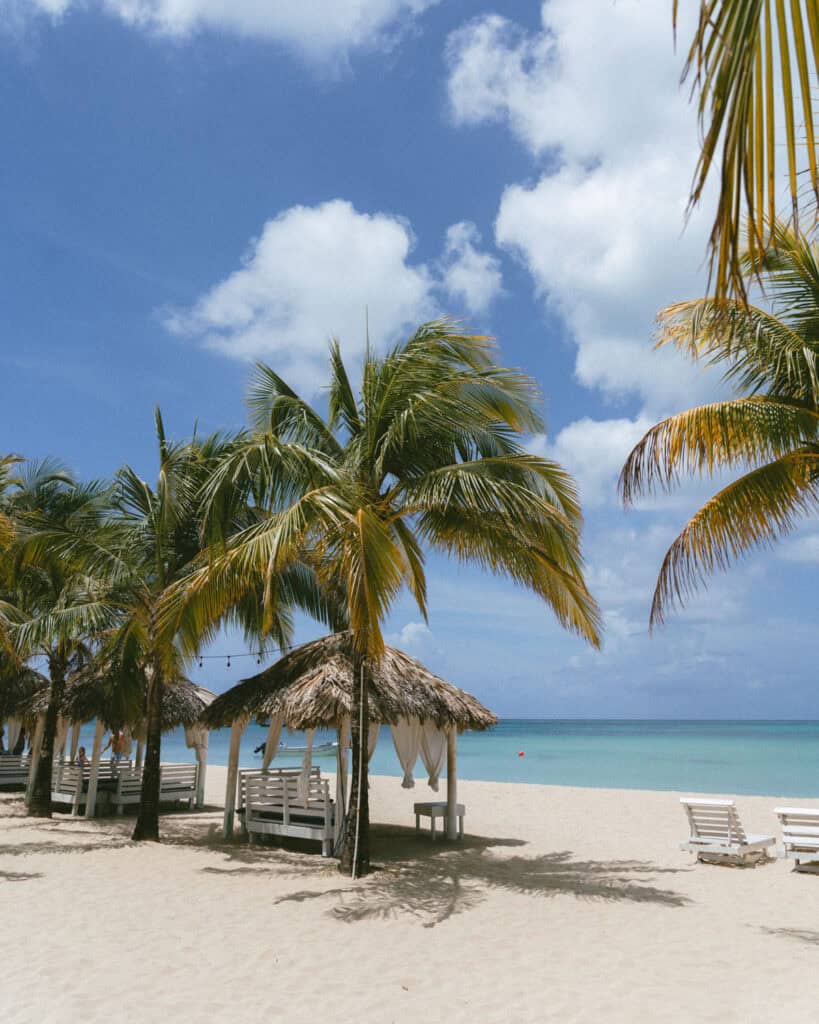 Big Corn Island, Nicaragua: The Underrated Corn Island 29 Palm trees and thatched-roof cabanas align the beachfront of Arenas Beach Club, capturing a serene view of the coastline and the tranquil Caribbean waters.