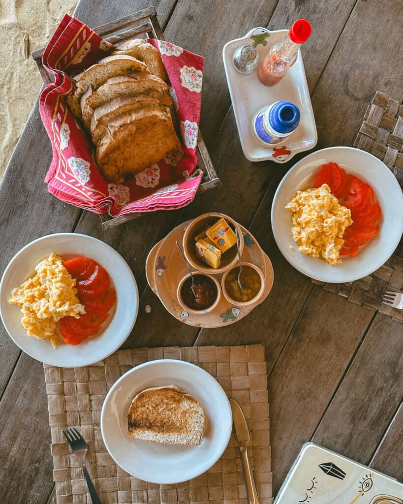 Big Corn Island, Nicaragua: The Underrated Corn Island 15 A hearty breakfast spread featuring scrambled eggs, fresh tomato slices, toast, and a basket of bread, accompanied by condiments and tropical jam, from our hotel on Big Corn Island.