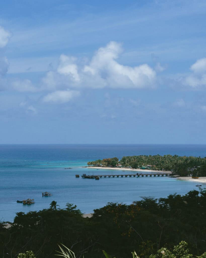 Big Corn Island, Nicaragua: The Underrated Corn Island 38 A scenic view from Quinn Hill Mirador, showcasing a bay with a long pier extending into the sea, surrounded by lush greenery on Big Corn Island.