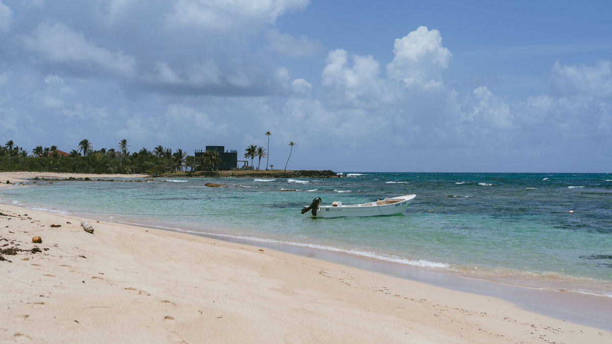 Corn Islands Nicaragua: Paradise on Big & Little Corn 4 A serene view of Silver Sand Beach on Big Corn Island, with clear turquoise waters and a lone boat near the shore.