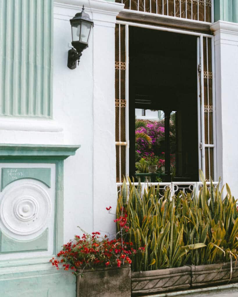 Granada, Nicaragua Travel Guide: Our Honest Thoughts 12 A different perspective of the Hotel Dario's doorway in Granada, revealing a glimpse of the courtyard and bright pink bougainvillea inside.