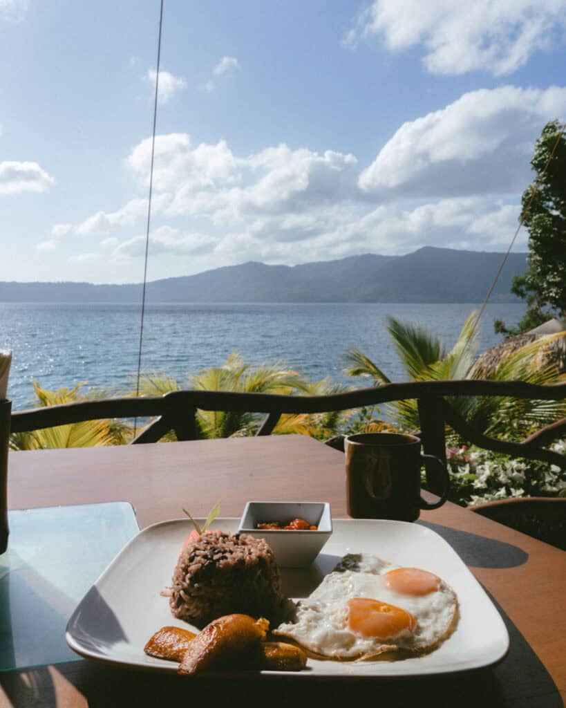 Nicaragua Travel Guide: Land of Lakes and Volcanoes 47 A traditional Nicaraguan breakfast of rice and beans, fried plantains, and sunny-side-up eggs, served on a wooden table overlooking the tranquil Laguna de Apoyo.
