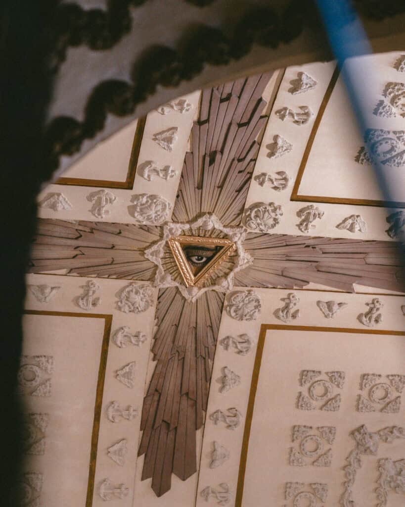 18 Best Things to Do in Leon, Nicaragua 10 The intricate ceiling design of León Cathedral, featuring a radiant "Eye of Providence" within a triangle, surrounded by ornate carvings and patterns.