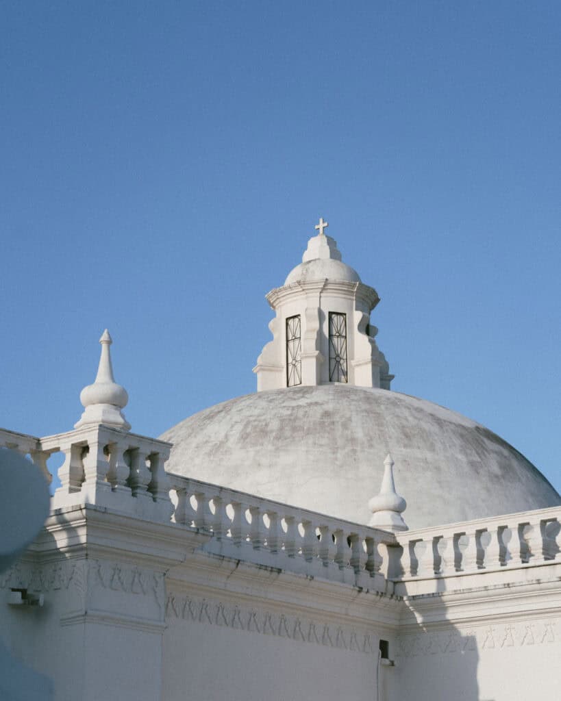 18 Best Things to Do in Leon, Nicaragua 13 A closer view of one of León Cathedral’s large domes with a cross on top, highlighting the intricate architectural features under a clear sky.