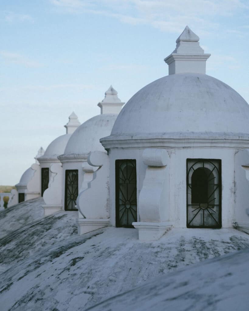 Nicaragua Travel Guide: Land of Lakes and Volcanoes 30 A row of smaller domes on León Cathedral’s rooftop, each with ornate windows, set against a pastel sky.