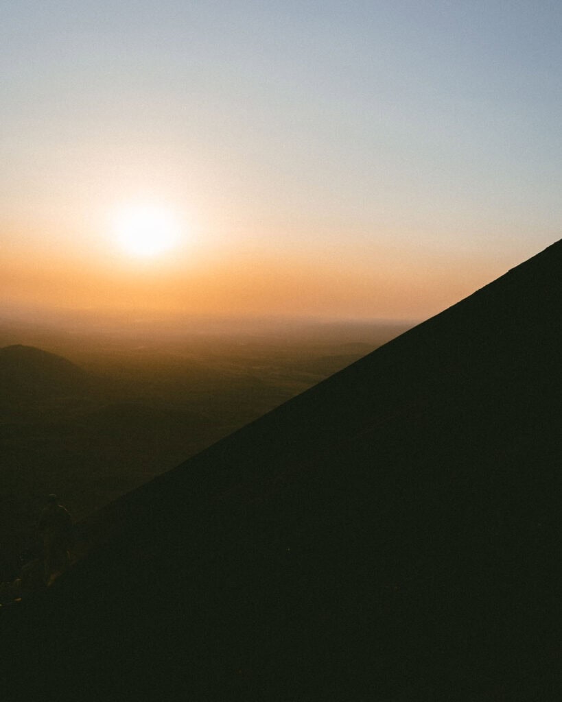 Epic Volcano Boarding in Nicaragua at Cerro Negro Volcano 19 The sun sets over the horizon, casting a warm glow across the volcanic landscape of Cerro Negro in Leon, Nicaragua.