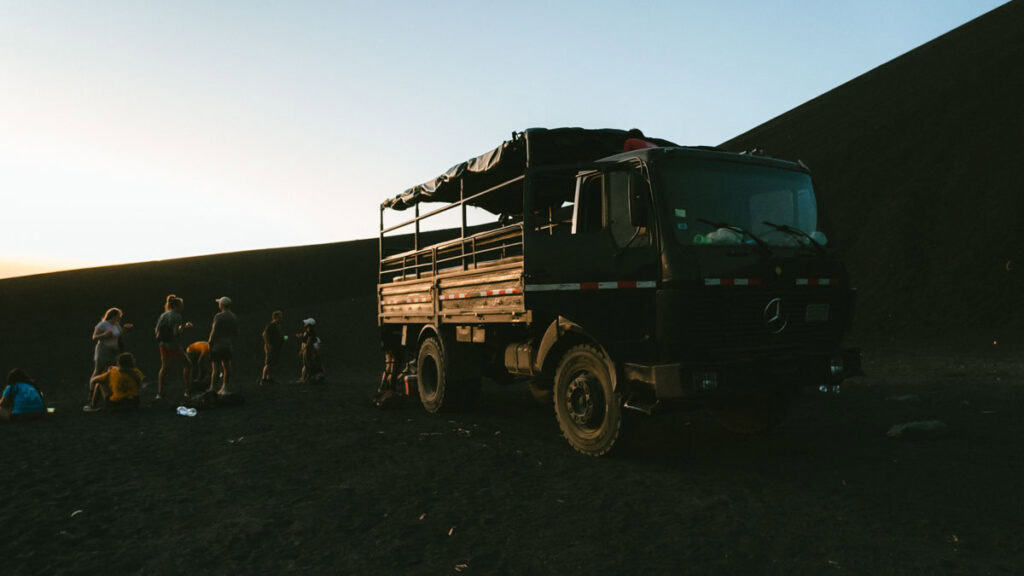 Epic Volcano Boarding in Nicaragua at Cerro Negro Volcano 25 A rugged black truck, used for transporting tourists to Cerro Negro, is parked against the volcanic backdrop during sunset in Leon, Nicaragua.