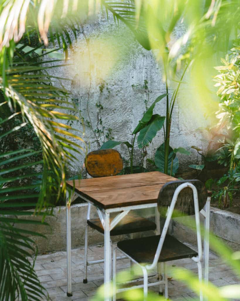 18 Best Things to Do in Leon, Nicaragua 32 A closer view of the inviting restaurant area in Coco Calala, Leon, with rustic furniture and vibrant greenery creating a serene ambiance.