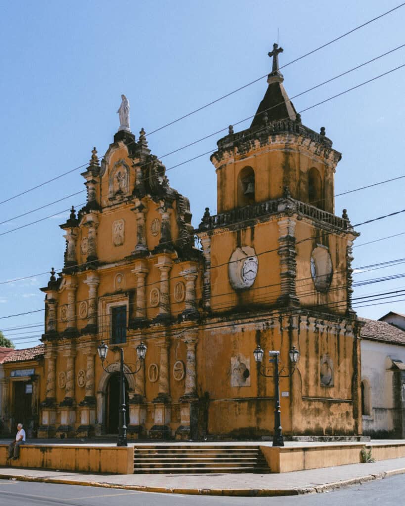 18 Best Things to Do in Leon, Nicaragua 35 A wide shot of Iglesia de la Recolección in León, Nicaragua, with its gothc style and vibrant yellow facade and detailed carvings.