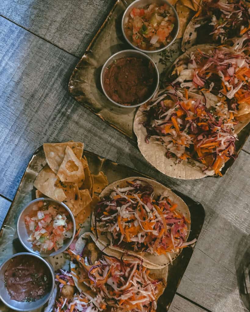 Leon, Nicaragua Travel Guide: The City of Revolution 30 Two plates loaded with tacos, little jars of salads and salsas and tortilla chips from Coco Calala, a cafe in Leon, Nicaragua.