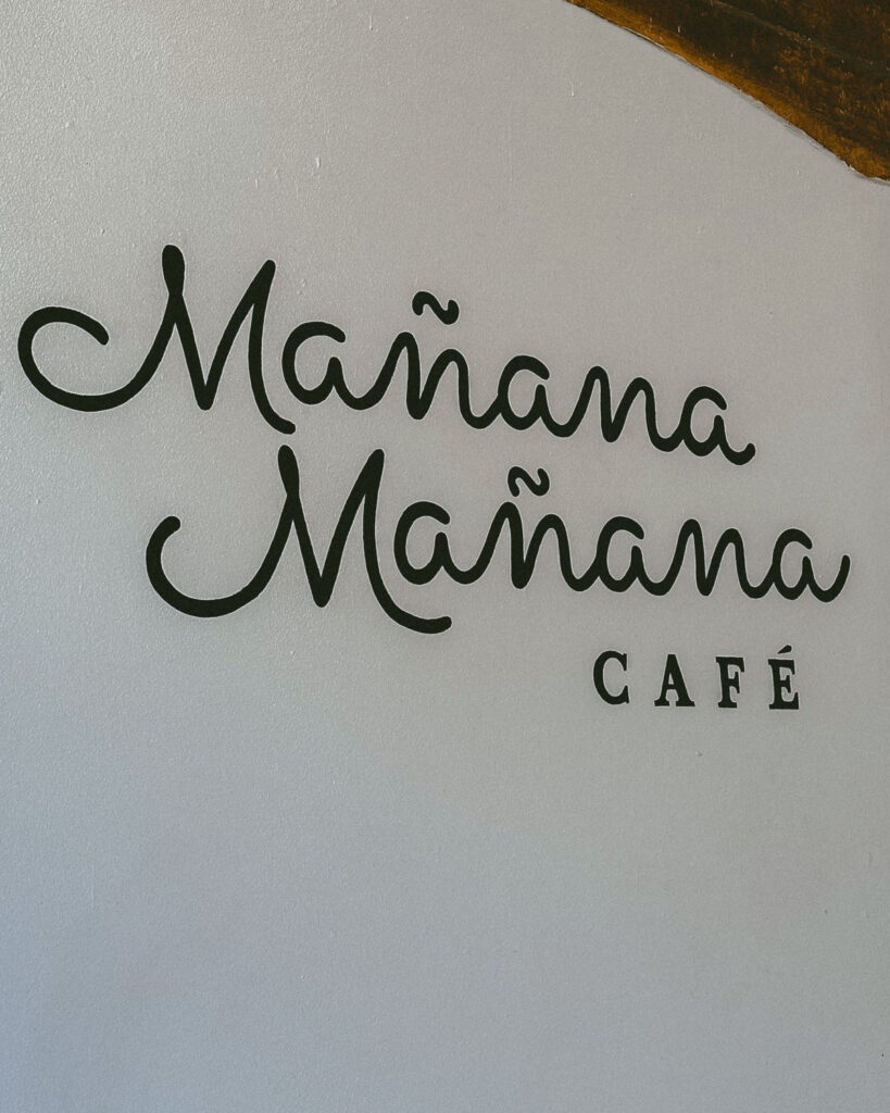 Leon, Nicaragua Travel Guide: The City of Revolution 25 The logo of Mañana Mañana Café, featuring elegant cursive lettering on a simple white wall in León, Nicaragua.