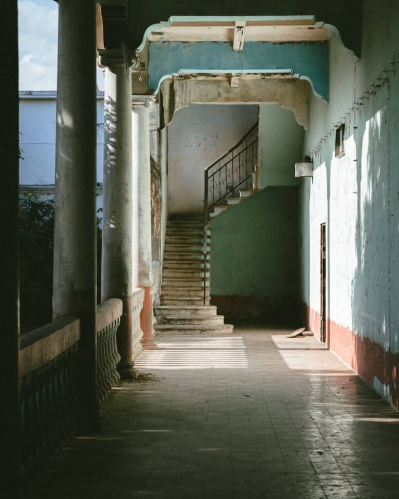 18 Best Things to Do in Leon, Nicaragua 17 The interior of the Revolution Museum in León, featuring an old staircase and sunlight streaming through the corridor.