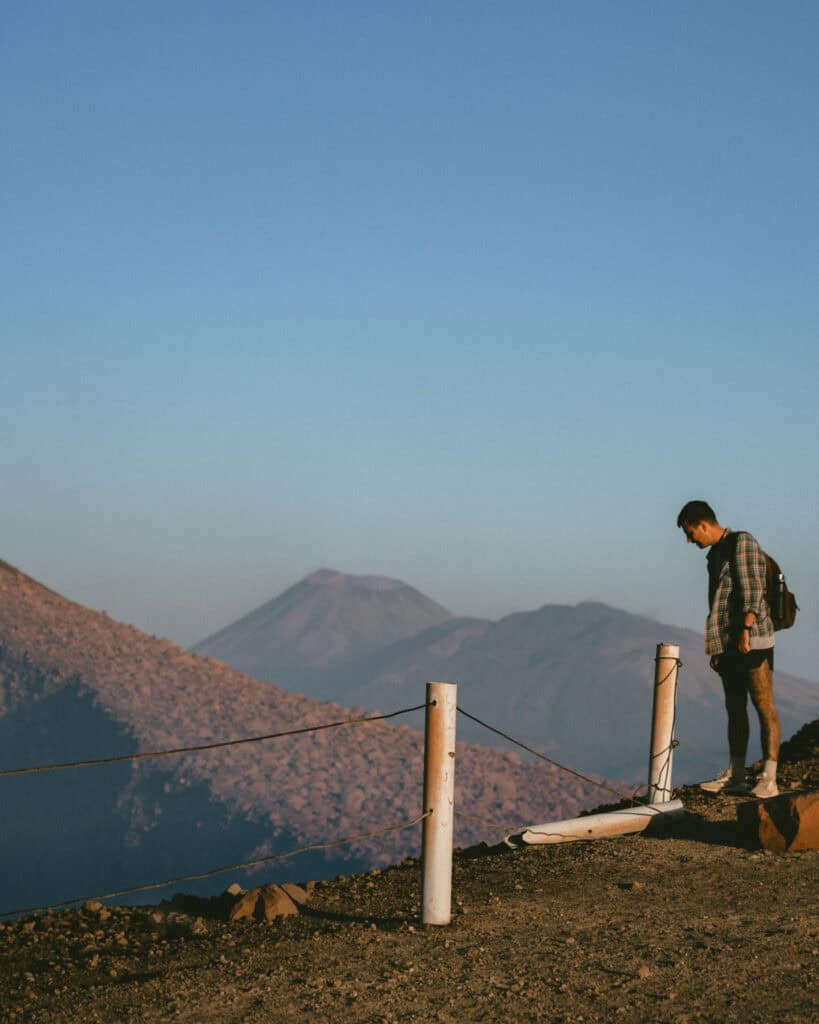 Hiking Telica Volcano in Nicaragua: A Magical Sunrise 5 Brayden standing near a safety railing overlooking the crater of Telica Volcano, with surrounding volcanic ridges in the background.
