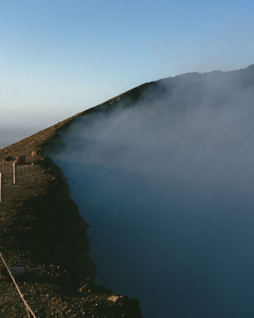 Hiking Telica Volcano in Nicaragua: A Magical Sunrise 7 Dense smoke rising from the crater of Telica Volcano, partially obscuring the steep volcanic slopes under the bright sky.