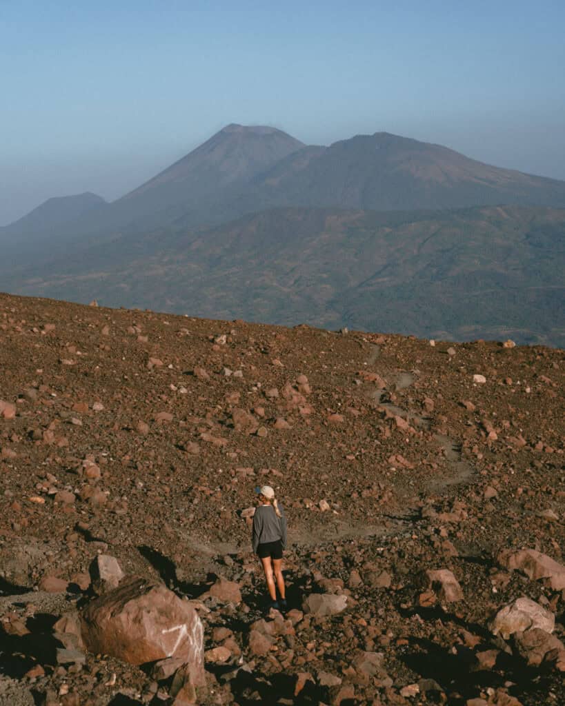 Hiking Telica Volcano in Nicaragua: A Magical Sunrise 16 Sally walking along a rugged path at Telica Volcano, with expansive views of León’s volcanic range in the background.