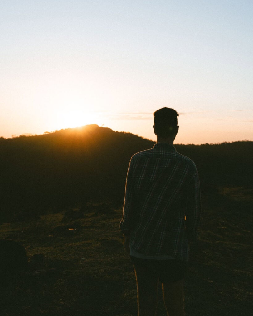 Hiking Telica Volcano in Nicaragua: A Magical Sunrise 11 Brayden standing in silhouette at sunrise on Telica Volcano, with the sun rising over a distant ridge.