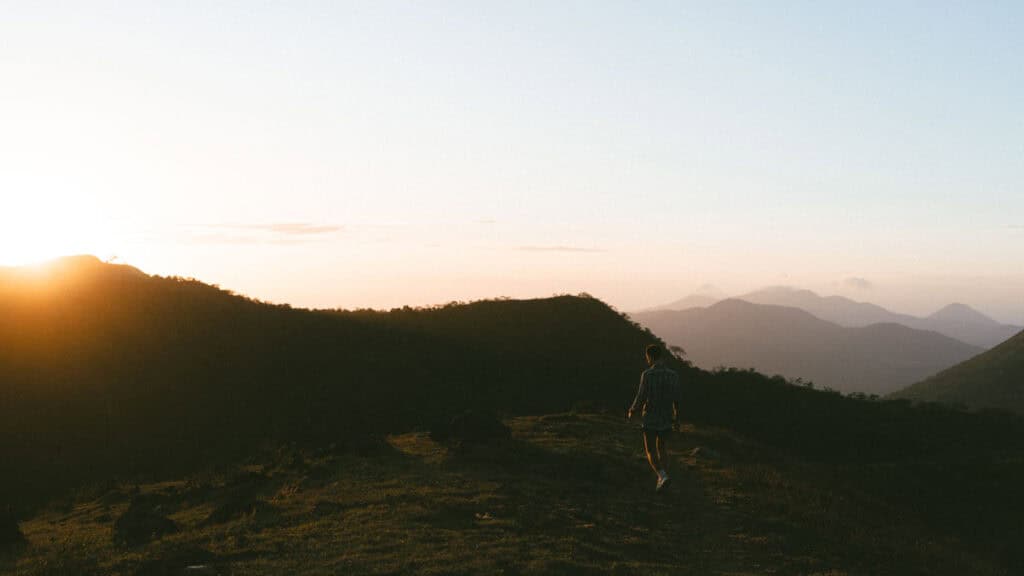Epic Volcano Boarding in Nicaragua at Cerro Negro Volcano 9 A breathtaking sunrise over the hills of Telica Volcano, with Brayden walking along a ridge and soft light spreading across the valley.