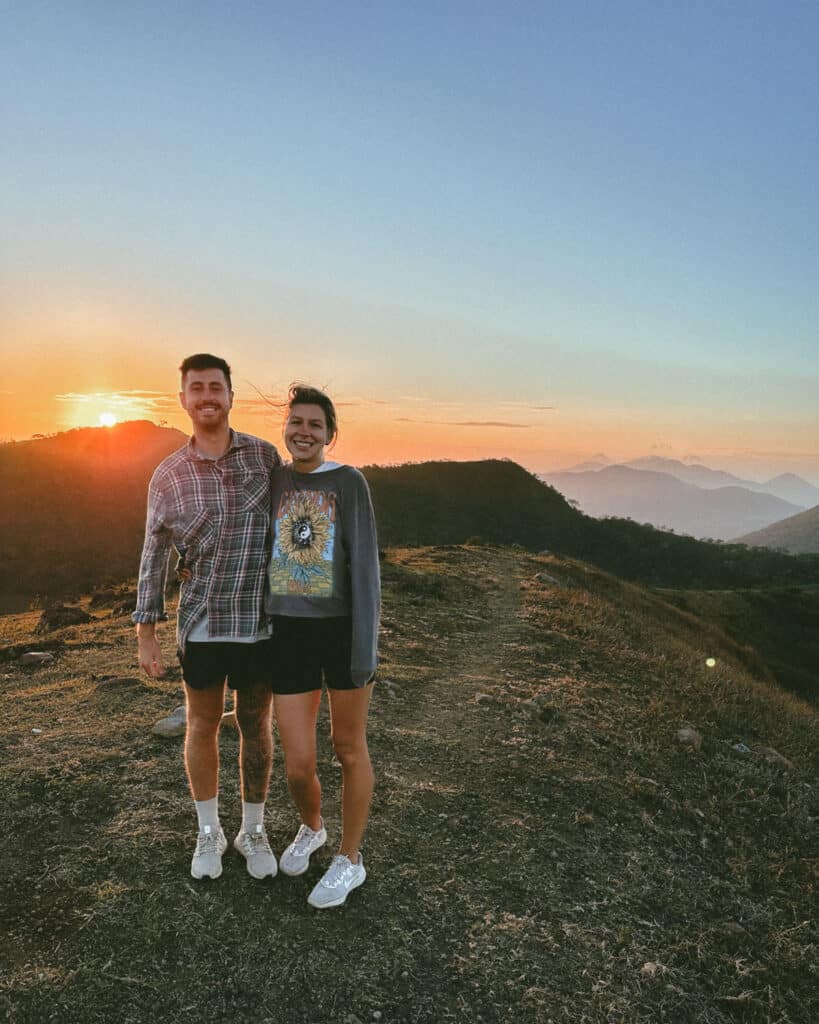 Hiking Telica Volcano in Nicaragua: A Magical Sunrise 9 Sally and Brayden standing together at sunrise on Telica Volcano, with warm light illuminating the mountainous landscape.