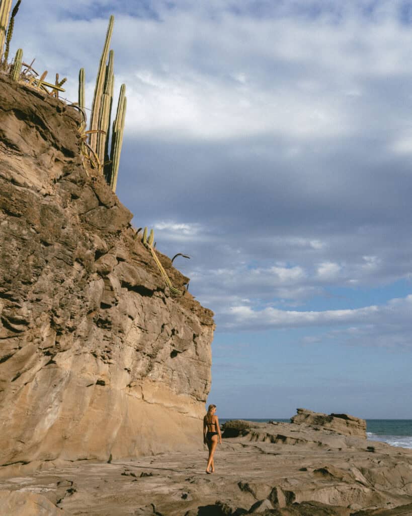 Popoyo, Nicaragua Travel Guide: Surf, Sand and Sunsets 27 Sally standing near large tidal pools and rocky cliffs with cacti in Guasacate, Popoyo, Nicaragua.