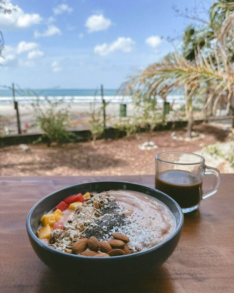 Popoyo, Nicaragua Travel Guide: Surf, Sand and Sunsets 30 A smoothie bowl topped with granola, almonds, and coconut flakes, served with coffee and a view of the beach in Popoyo at Cafe Con Leche.