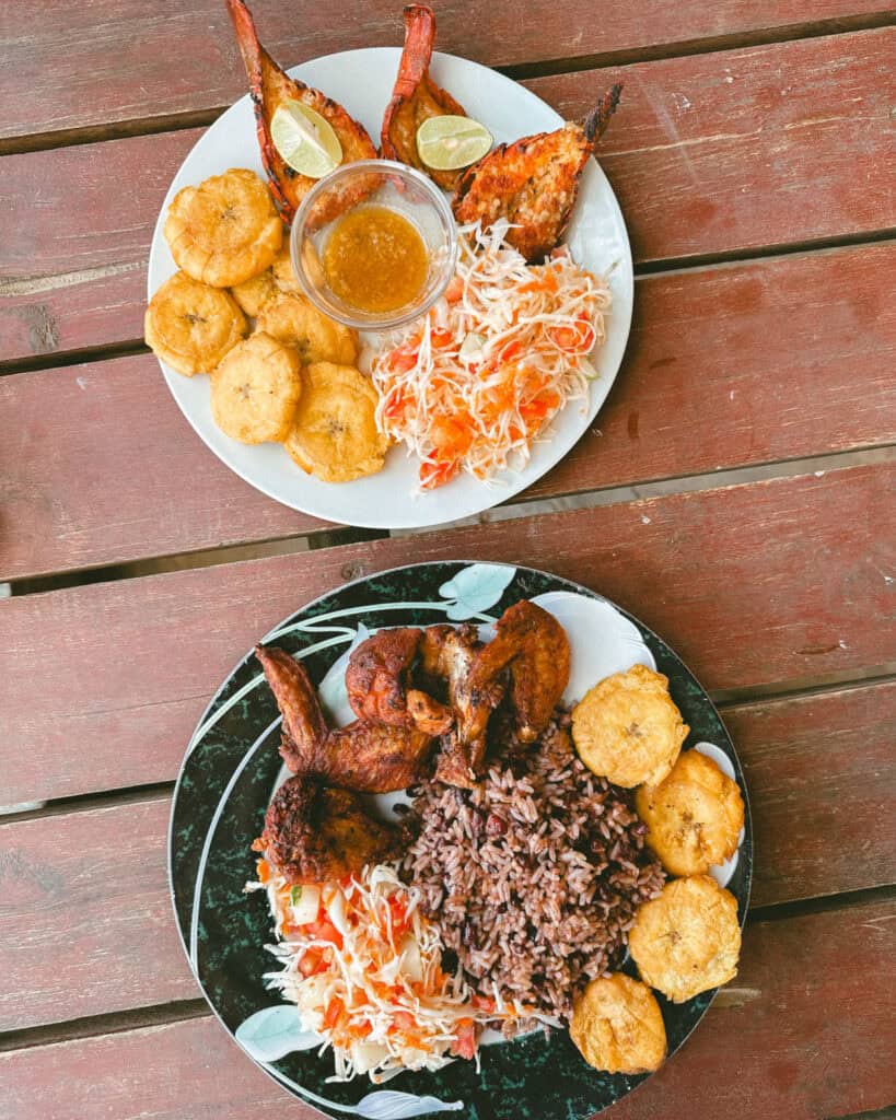 Nicaragua Travel Guide: Land of Lakes and Volcanoes 46 Two plates of traditional Nicaraguan food with grilled chicken, lobster, plantains, rice, and salad at Soda Camping Luna in Popoyo, Nicaragua.