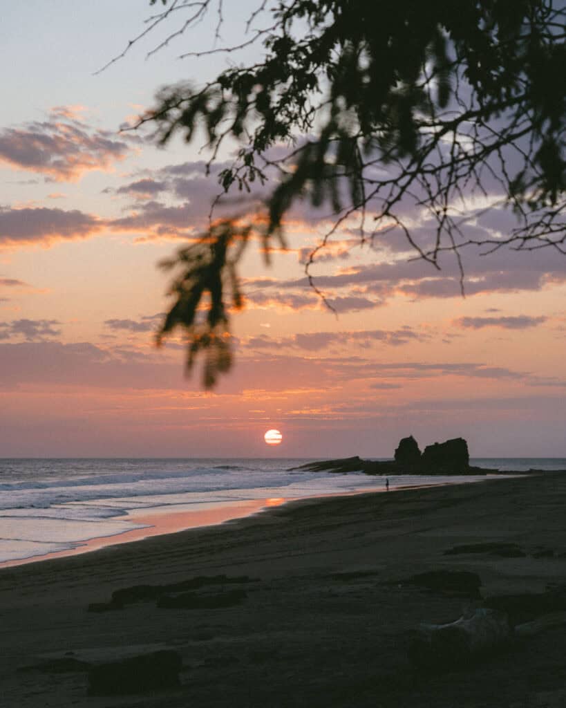 Popoyo, Nicaragua Travel Guide: Surf, Sand and Sunsets 18 A colorful sunset over the ocean, with Magnific Rock prominently silhouetted in the background in Popoyo, Nicaragua.