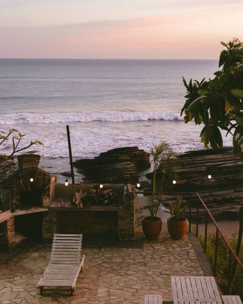 Popoyo, Nicaragua Travel Guide: Surf, Sand and Sunsets 35 A cozy patio at Magnific Rock Bar with a fire pit and lounge chairs overlooking the beach at sunset, Popoyo, Nicaragua.
