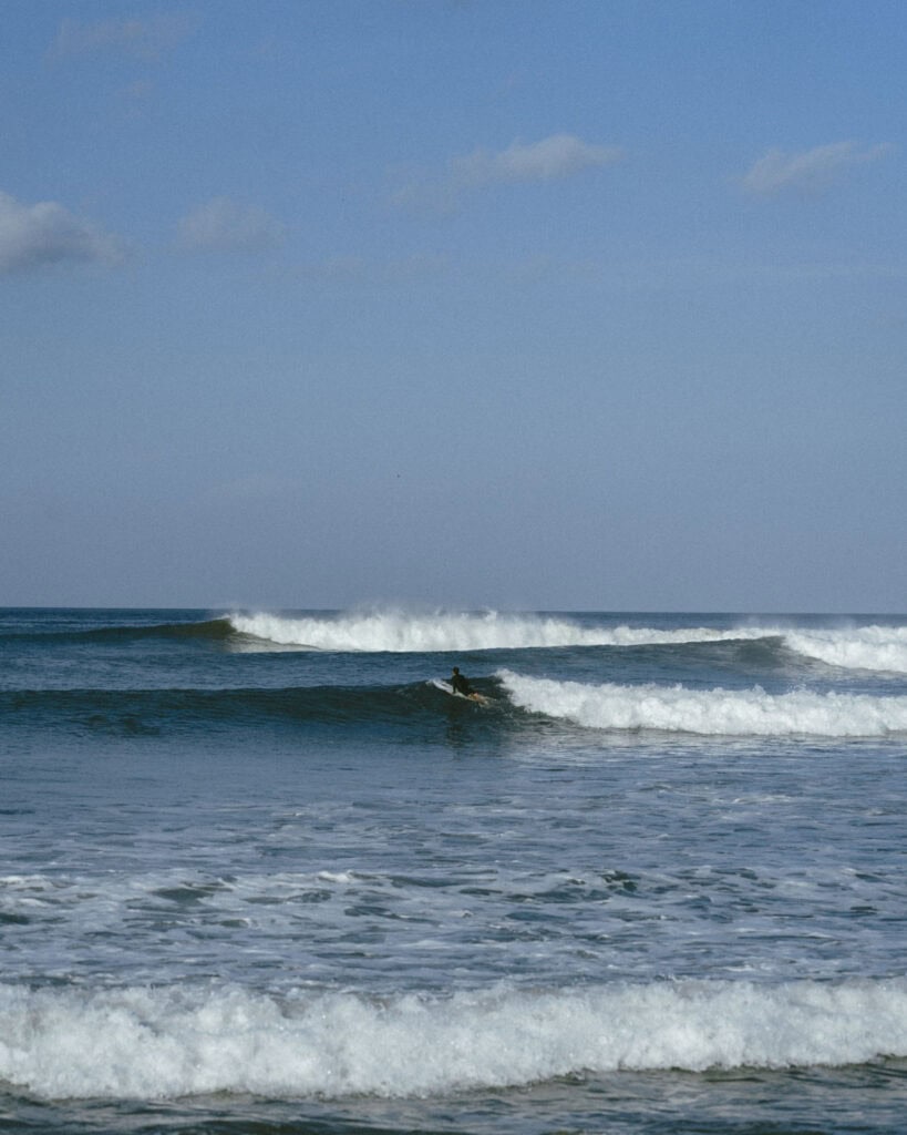 Popoyo, Nicaragua Travel Guide: Surf, Sand and Sunsets 1 Brayden mid-surf at Beginner Bay, Popoyo, with rolling waves stretching across the horizon.