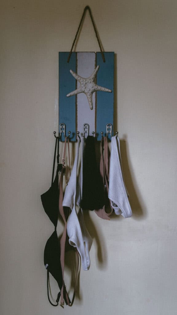 San Juan del Sur, Nicaragua Travel Guide: Worth the Hype? 30 A decorative wall-mounted rack with various bikinis hanging, set against a light-colored wall in San Juan del Sur, Nicaragua, featuring a starfish design.